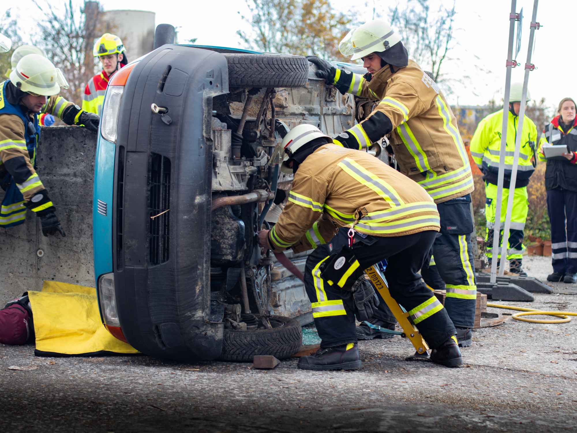 Wochenende der offenen Tore Feuerwehr (1) Feuerwehrleute bergen ein verunfalltes Auto das auf der Seite liegt.
