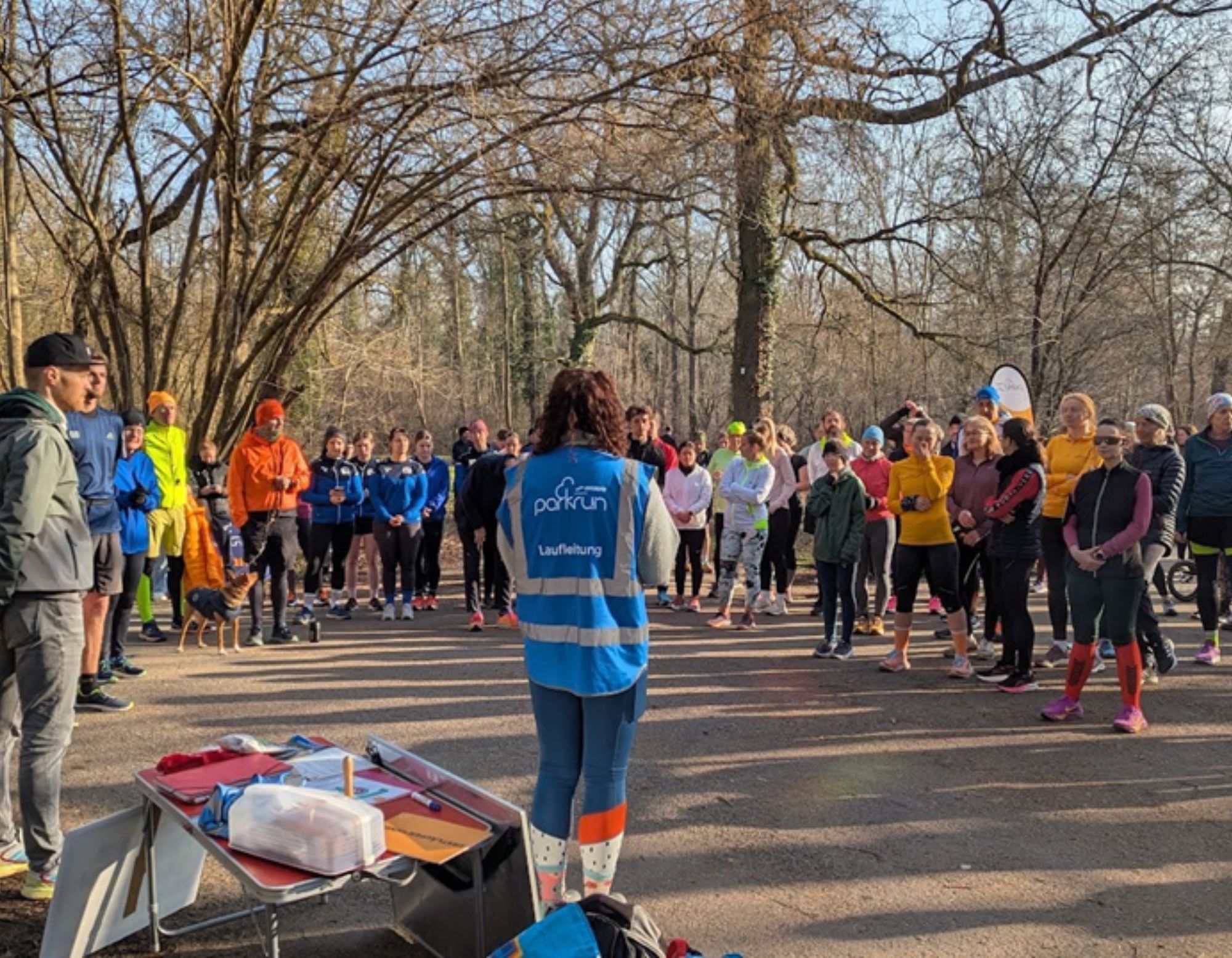 ein Gruppe von Teilnehmenden am Neckarau parkrun mit der Laufleiterin