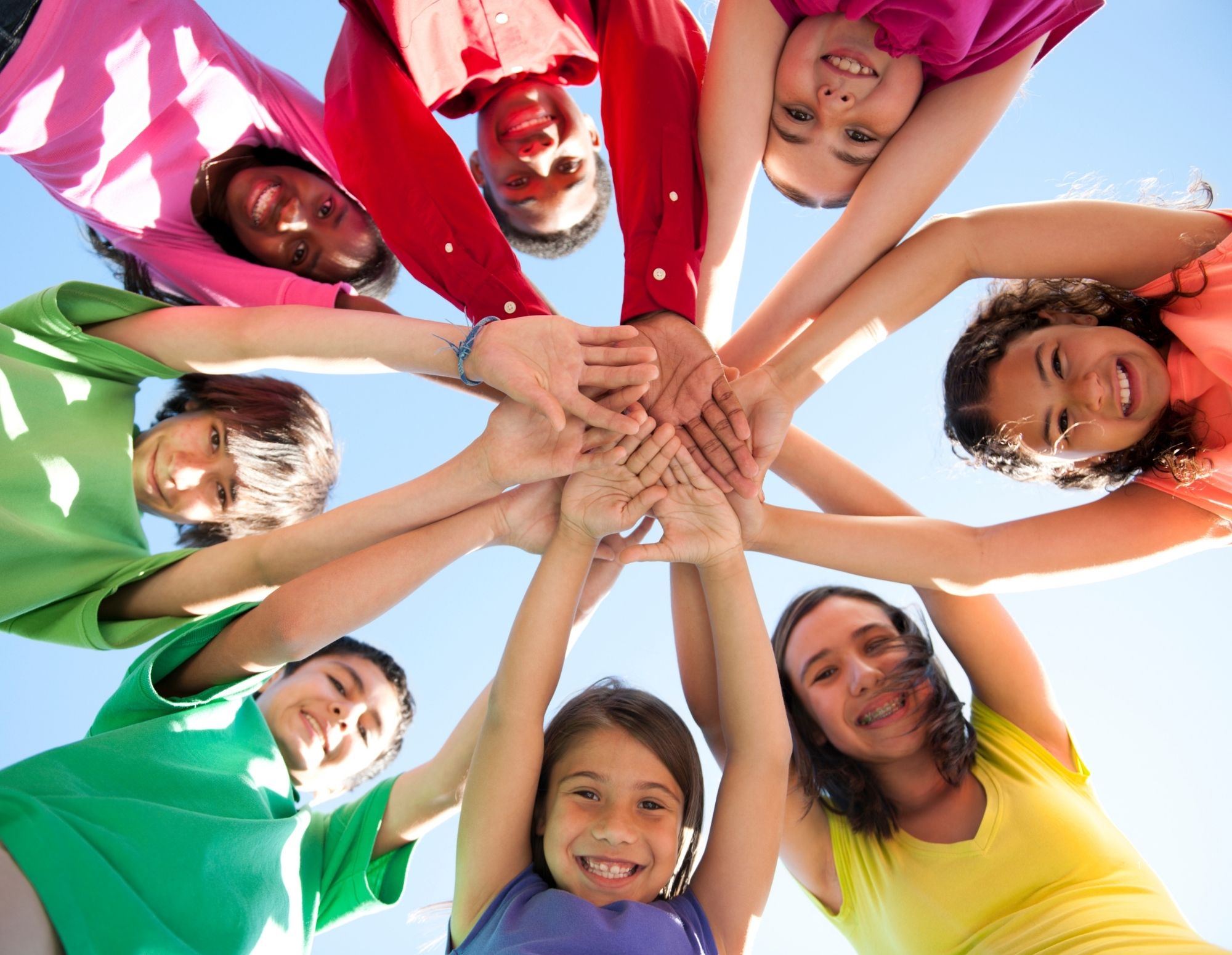 Viele Kinderhände fassen sich an