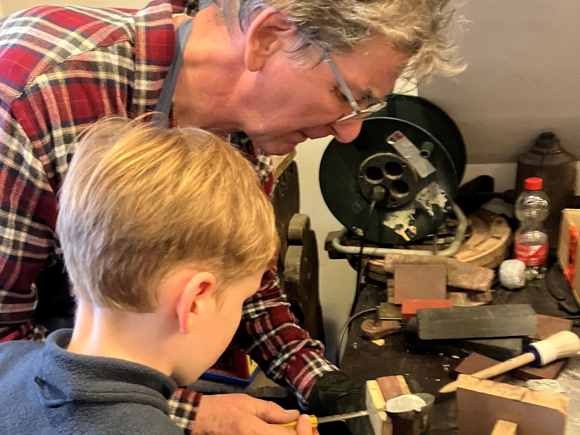 Mann zeigt einem Kind das Oster-Zinngiessen